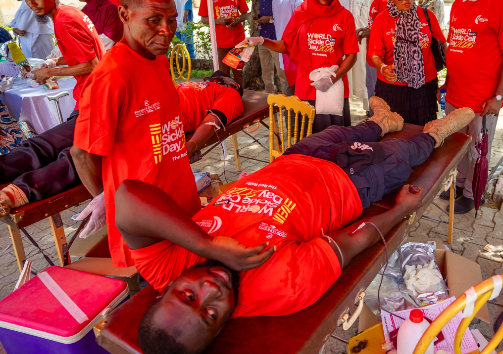 An SCFN blood-drive volunteer assisting a reclining donor.