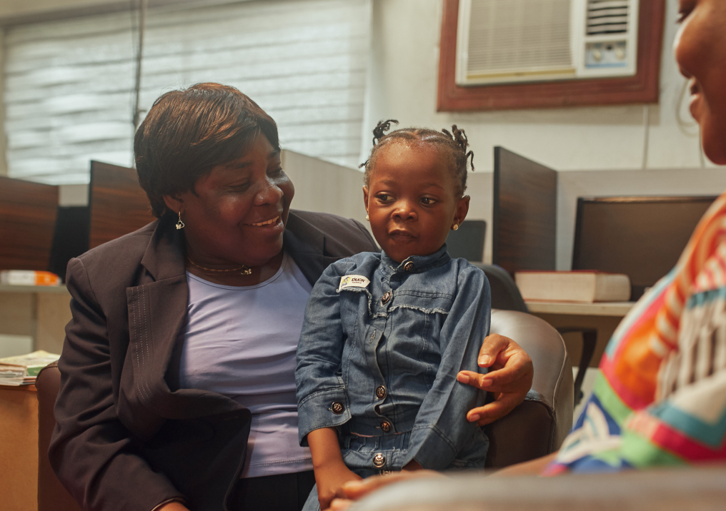 A mother holding her child during a genetic counselling session.