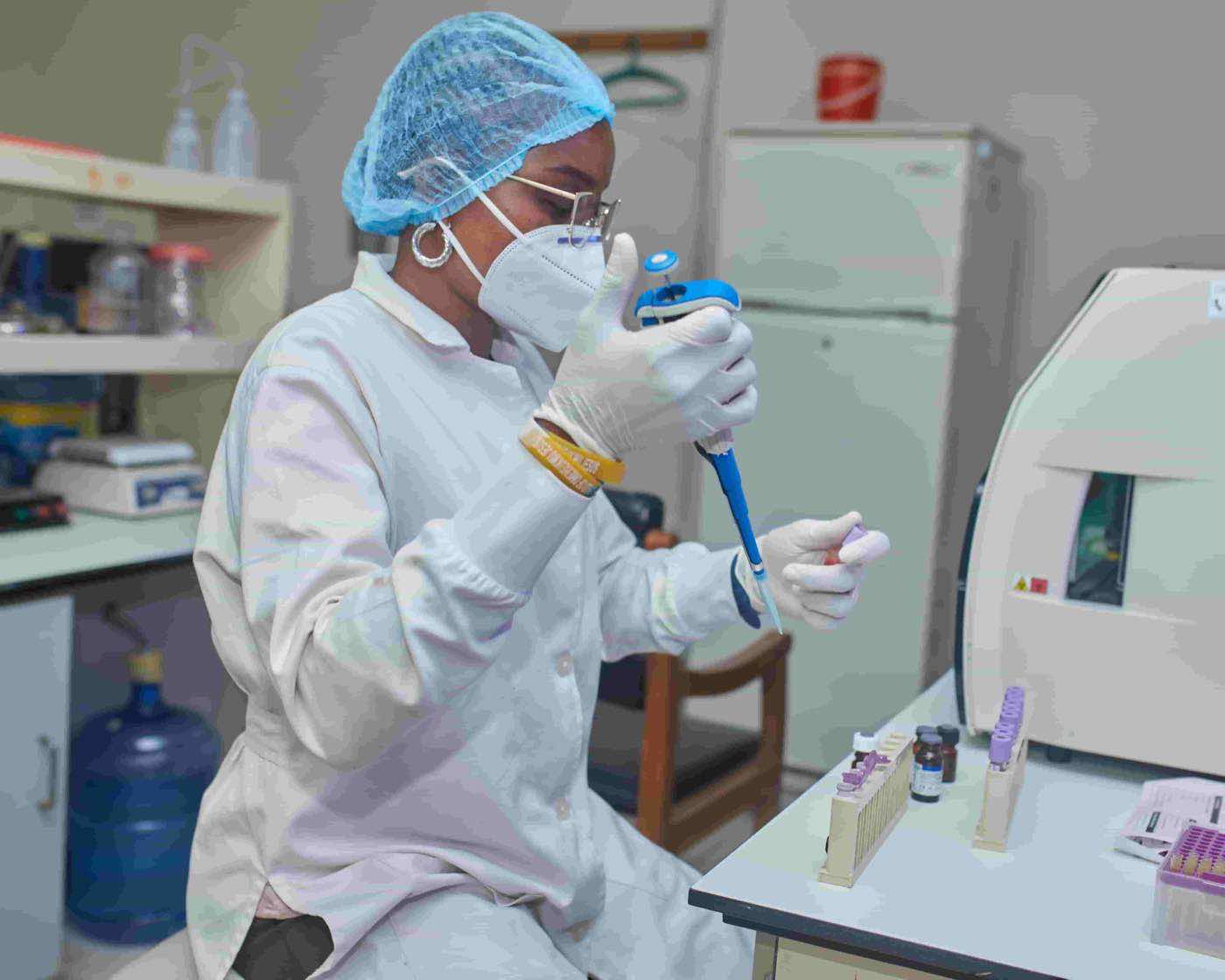Lab scientist handling diagnostic equipment for haemoglobin testing.