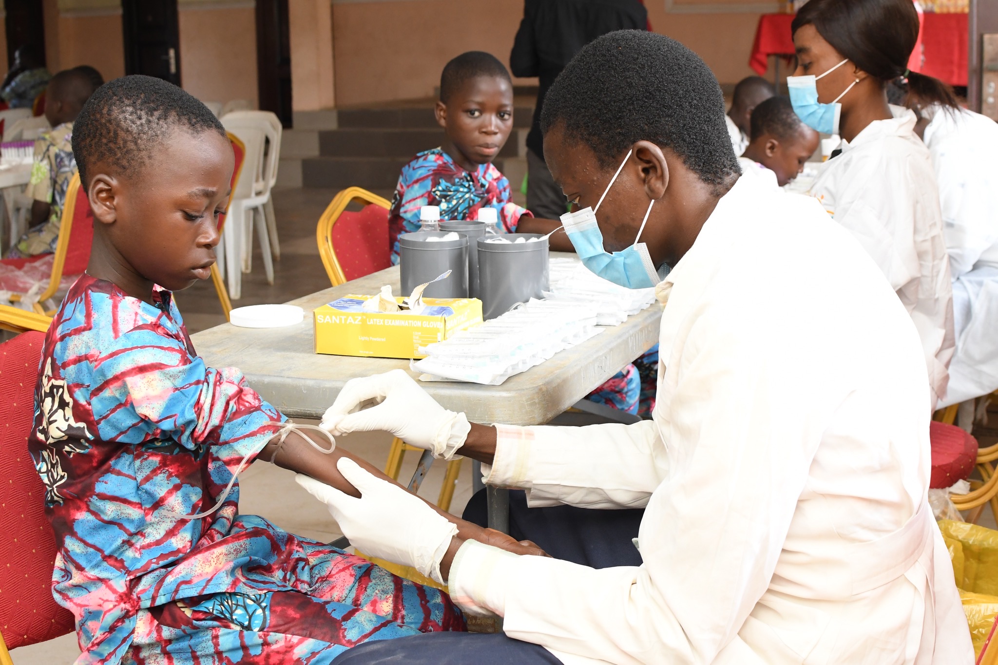 Healthcare worker caring for a child during a sickle cell clinic visit.